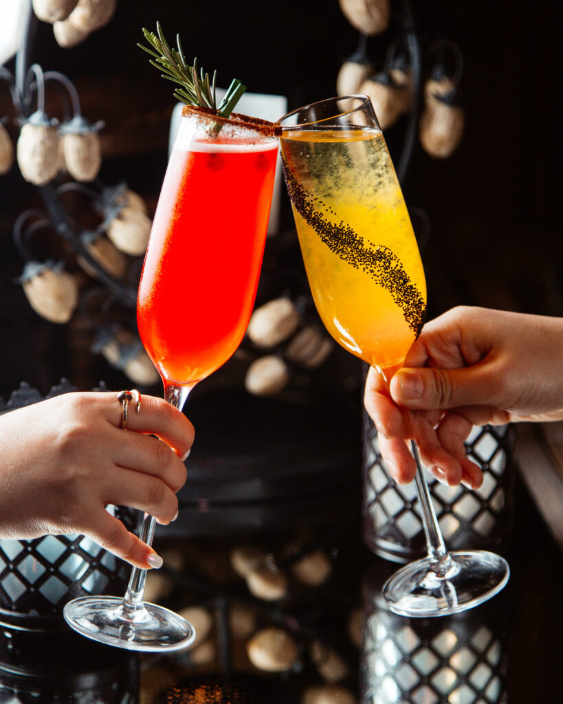 Filles qui trinquent avec des verres à champagnes remplis avec des mocktails